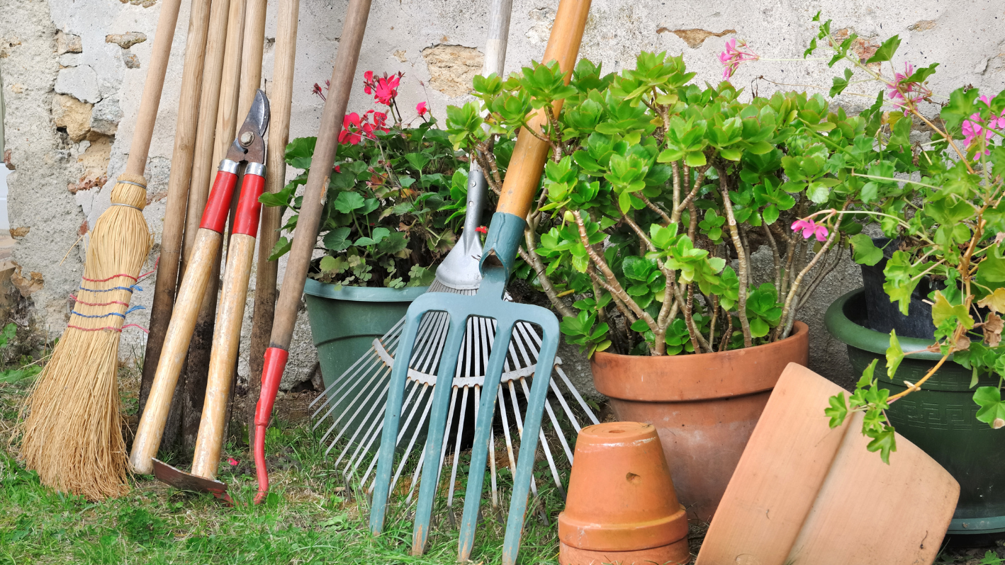 A pile of gardening tools sitting on top of a grass covered field